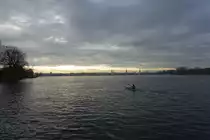 Hamburg am 11.12.2021: einsamer Paddler auf der Au�enalster vor der Stadtkulisse /