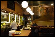 Das  Luisencaf�  eine der vielen urig skurillen Szenekneipen in der kleinen aber feinen Altstadt in Wuppertal rund um Laurentius-Platz und Luisenstra�e. Hier hat Wuppertal mit seinen sehr alten gro�st�dtischen Arbeiter- und Wohnquartieren ein kreatives multikulturelles Flair das einzigartig ist. Im Hintergrund ein geniales Bild des Wuppertaler Malers und Grafikers Wolf Erlbruch das
die dekadente Selbstinszenierung der hedonistisch,neoliberalen m�chtegern Elite auf's vortrefflichste darstellt.