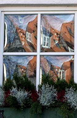 Verzerrter Spiegelbildblick der Fachwerkhuser in einem Fenster im Fischerviertel von Ulm.