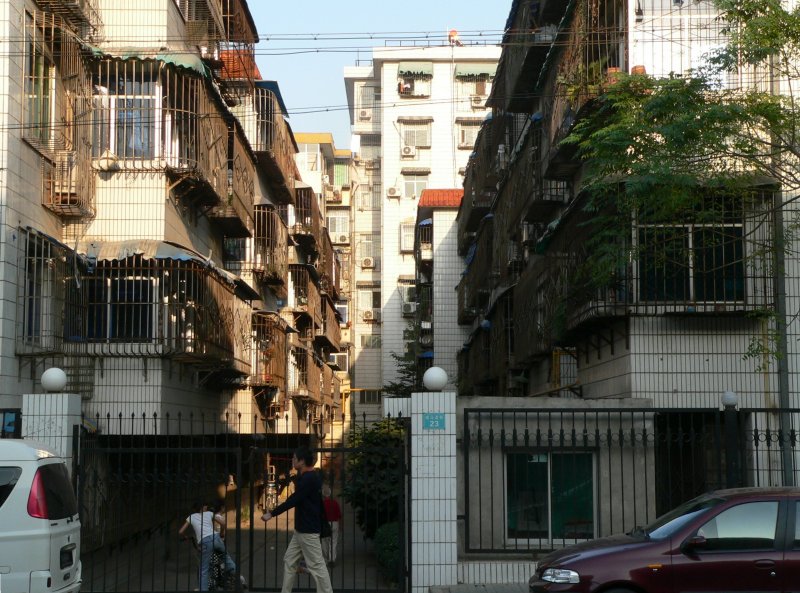 Wohnen in China. Die Fenster sind vergittert, der Zugang zum Objekt wird oft durch einen Pfrtner gesichert. Generell gibt es in China viele Arbeitspltze, die in Europa lange wegrationalisiert wren. So gibt es mehrere Einweiser fr den Parkplatz vor Restaurants, menschliche Trffner, Straenfeger u.v.m. 09/2007