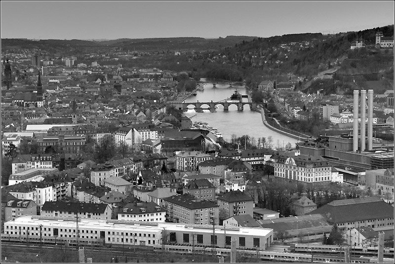 Wrzburg mit der Alten Mainbrcke. Dahinter sieht man die Ludwigsbrcke. Links oben im Bild kann man, schaut man genau hin die groe Talbrcke der Autobahn A3 erkennen. Das Heizkraftwerk diesmal ganz rechts und darber ein kleiner Teil der Festung Marienberg. Am unteren Bildrand verluft die Bahntrasse. Der Hbf befindet sich links auerhalb des Bildes. 15.4.2006 (Matthias)