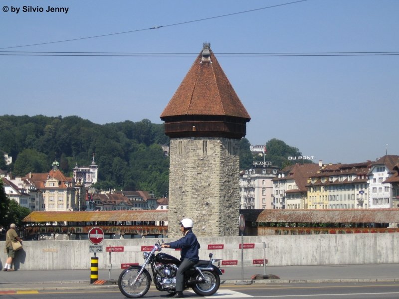 Wunderschöner Sommertag in Luzern vor der Kappelerbrücke, dem Luzerner Wahrzeichen. Da nimmt sich auch der Motoradfahrer im Vordergrund nicht die Freude eine Ausfahrt zu machen. Luzern 28.7.05