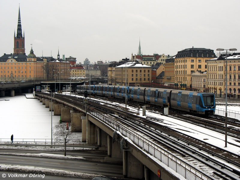 Zwischen den Stationen Gamla Stan und Slussen fährt die Stockholmer U-Bahn oberirdisch; im Hintergrund links die Riddarholmskyrkan, die Grabkirche vieler schwedischer Könige - 15.03.2006
